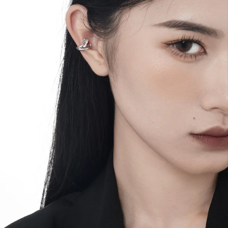 Femme portant la manchette d'oreille en argent 925 et agate blanche, vue de face minimaliste.