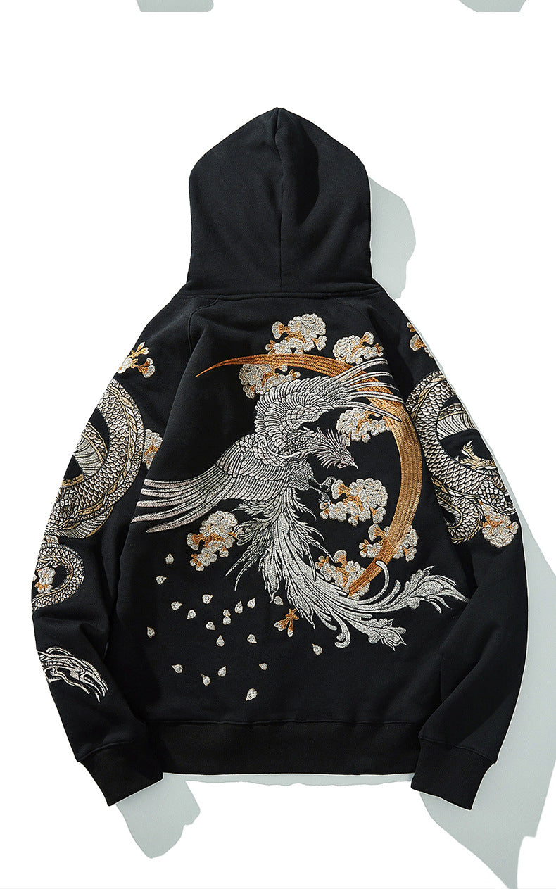 Gros plan sur la texture du coton noir et la précision des fils argentés de la broderie dragon.
