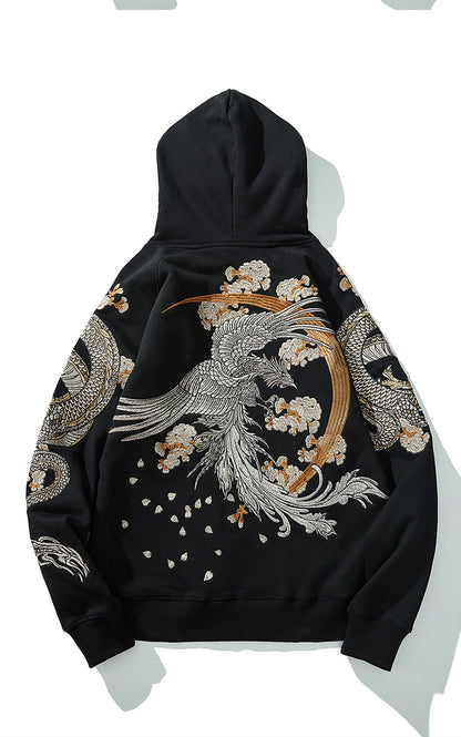 Gros plan sur la texture du coton noir et la précision des fils argentés de la broderie dragon.