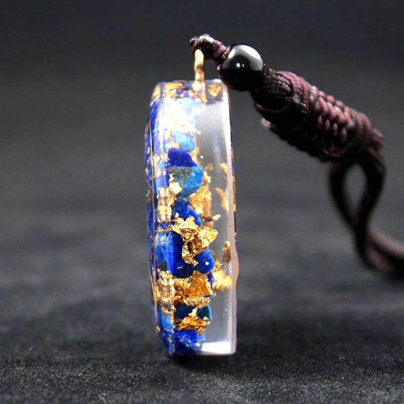 Vue de profil du pendentif orgonite montrant l'épaisseur de la résine et les éclats de lapis-lazuli.