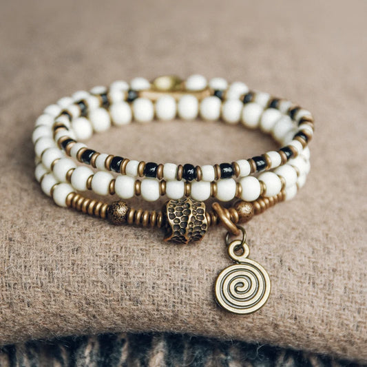Bracelet Tibétain Multirang Os de Yak et Verre de Murano – Breloque en Laiton Martelé