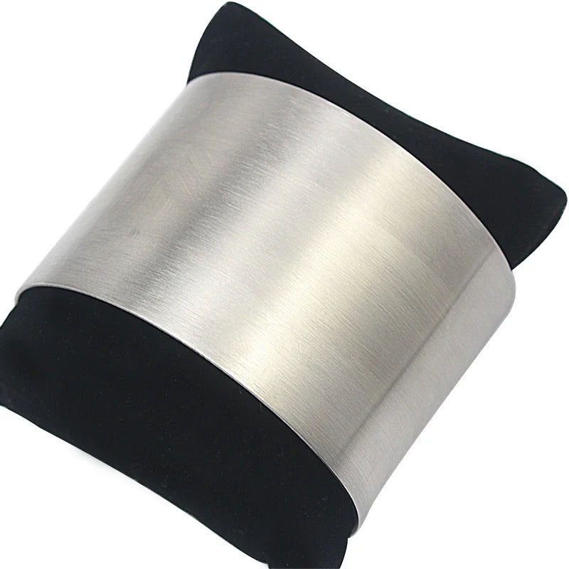 Manchette minimaliste argentée présentée sur un coussin de présentation noir
