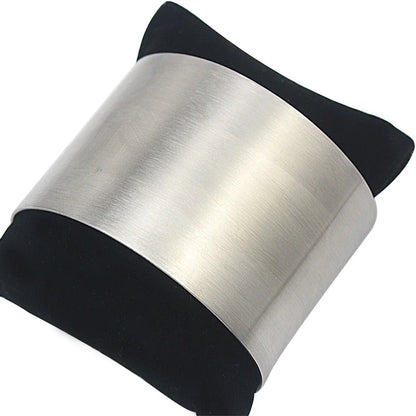 Manchette minimaliste argentée présentée sur un coussin de présentation noir
