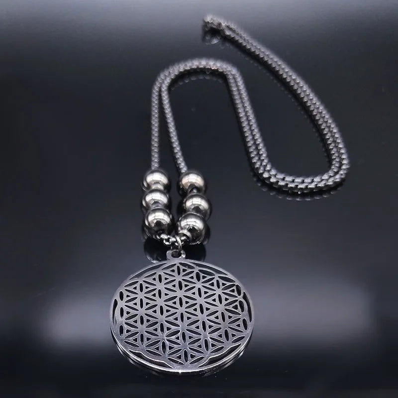 Collier Fleur de Vie en acier argenté posé sur une surface noire avec reflets élégants.