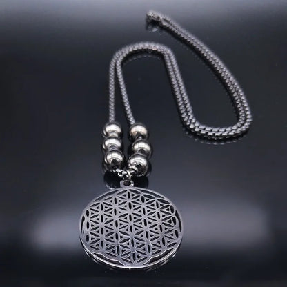 Collier Fleur de Vie en acier argenté posé sur une surface noire avec reflets élégants.