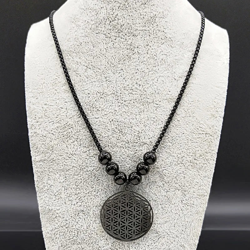 Collier géométrie sacrée noir présenté sur un buste d'exposition pour un rendu réaliste.