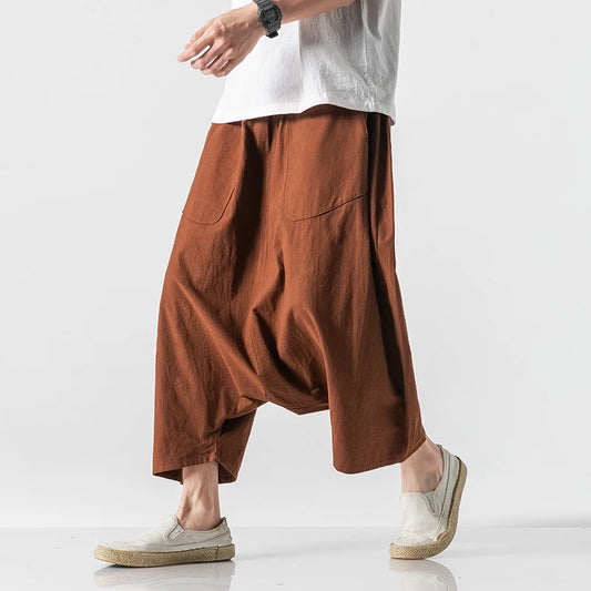 Pantalon sarouel large pour homme couleur marron terracotta porté avec des chaussures légères en toile