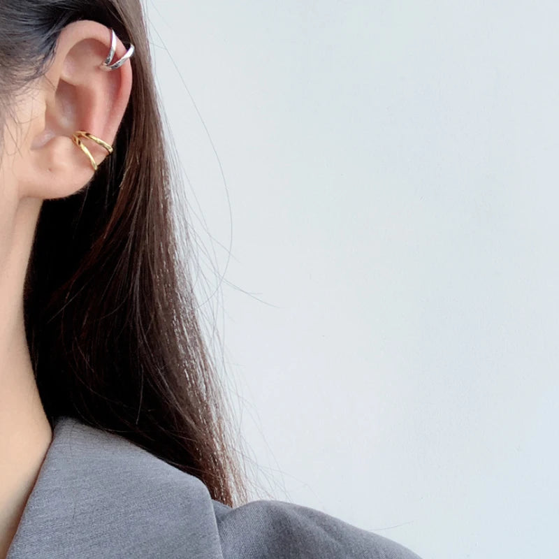 Accumulation de bagues d'oreilles géométriques argent et or pour un look superposé tendance.