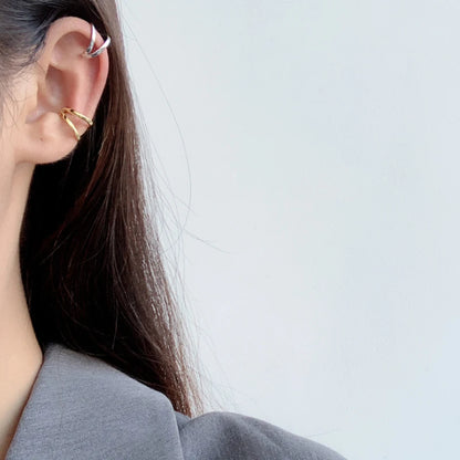 Accumulation de bagues d'oreilles géométriques argent et or pour un look superposé tendance.
