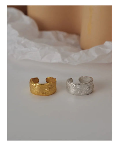 Vue rapprochée de la bague d'oreille large en argent martelé, design minimaliste chic.