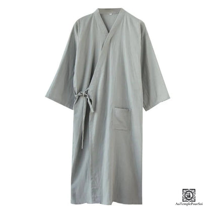 Kimono élégant de couleur gris clair, présentant une silhouette fluide et une simplicité chic. La pièce est mise en valeur par sa texture douce et son design épuré, idéal pour un confort stylé à la maison ou lors d'occasions spéciales.