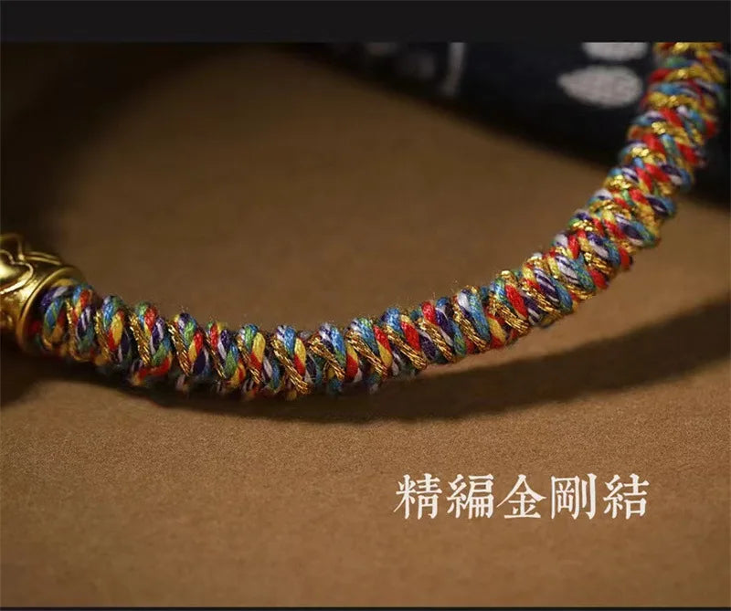 Bracelet tibétain artisanal multicolore avec perles de protection posé sur un fond neutre.
