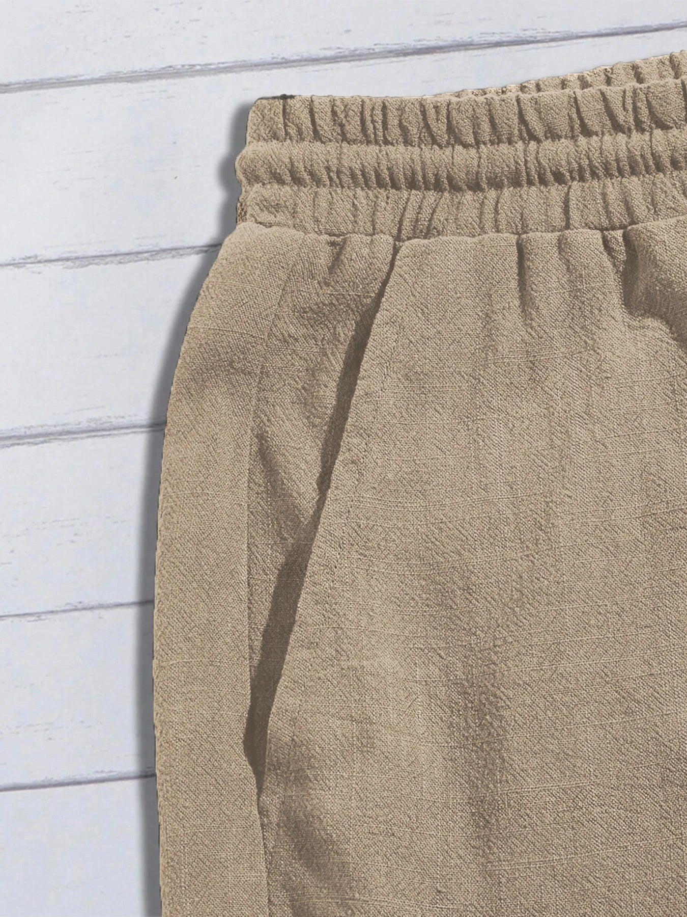 Zoom sur la poche latérale et la taille élastiquée confortable du short en lin.