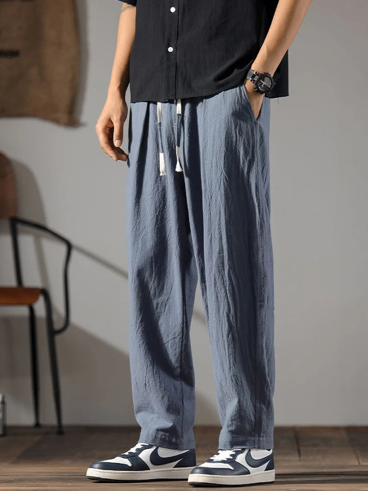 Détail du pantalon gris anthracite en mélange lin et coton, focus sur la matière respirante et le cordon.