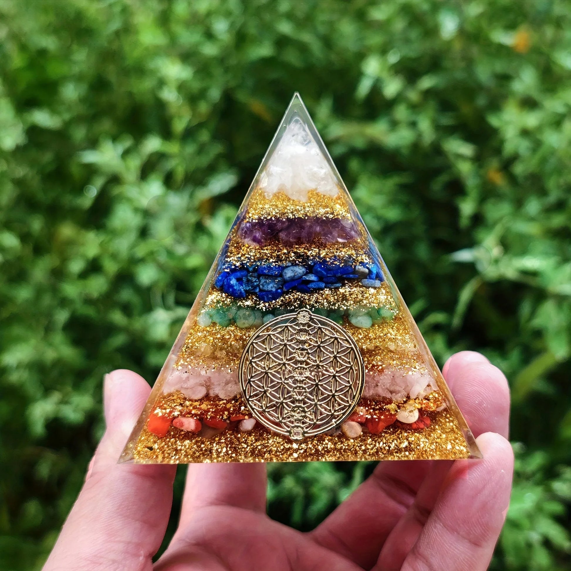 Face principale de la pyramide 7 chakras avec le symbole doré de la Fleur de Vie intégré dans la résine.