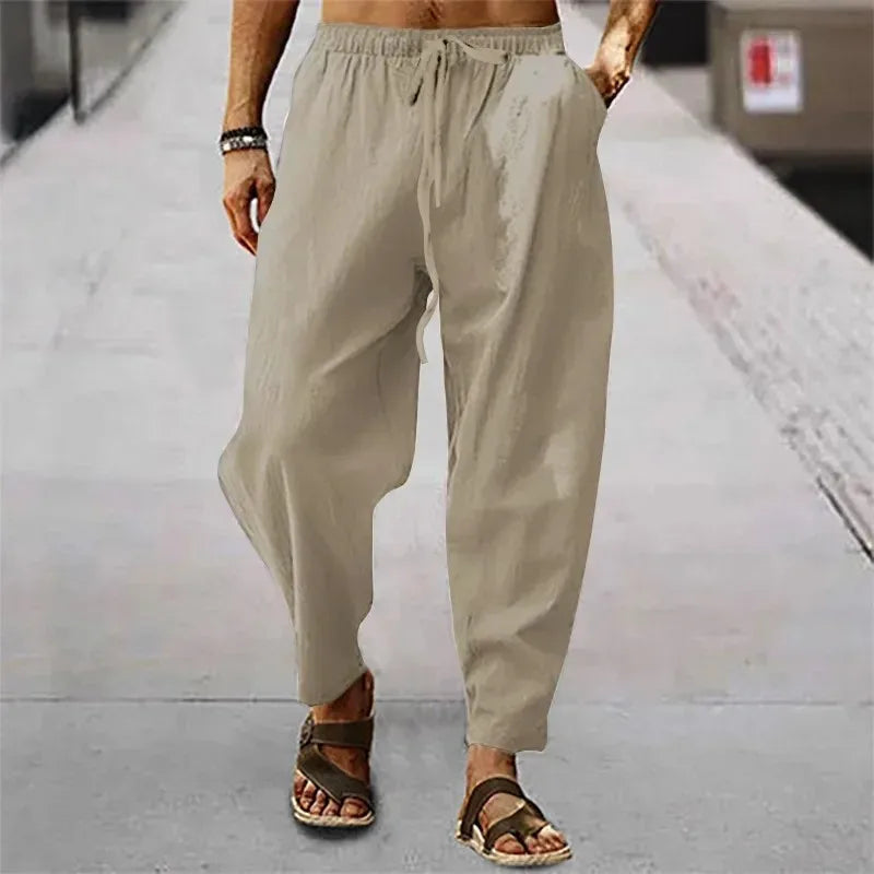Pantalon en lin beige sable, texture naturelle légère et coupe large pour un confort optimal.