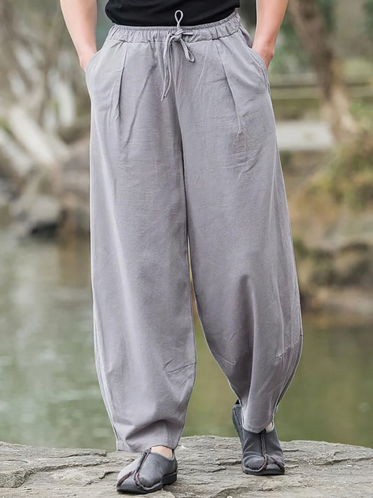 Pantalon large homme en lin et coton gris porté de face, coupe ample style zen et vintage.