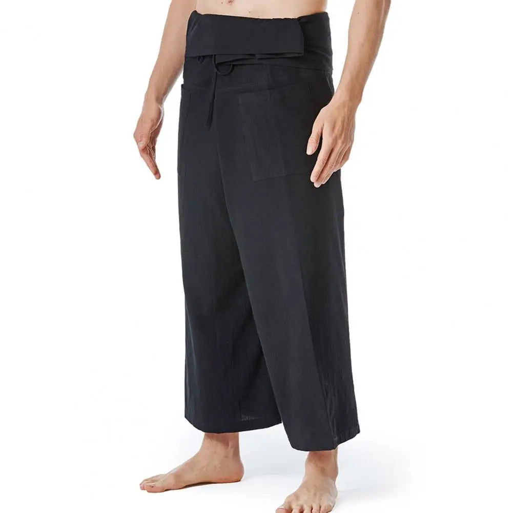 Pantalon sarouel homme en lin noir porté de profil soulignant l'aisance de mouvement et le cordon de serrage