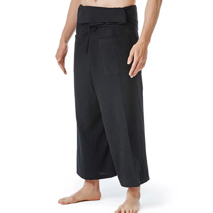 Pantalon sarouel homme en lin noir porté de profil soulignant l'aisance de mouvement et le cordon de serrage