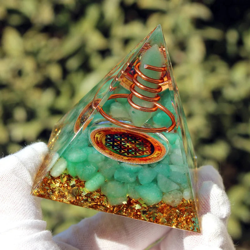 Pyramide de méditation artisanale montrant la transparence de la résine et les éclats de cuivre tourbillonnants.