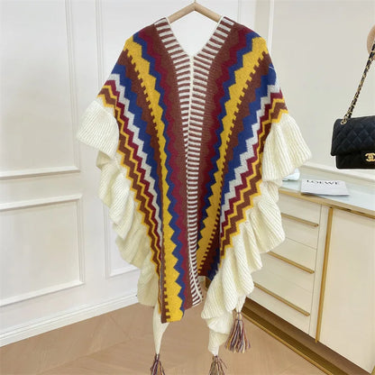 Poncho à motifs zig-zag marron et jaune avec finitions à volants et pompons colorés.