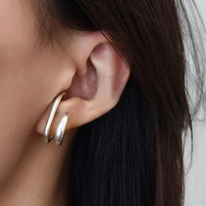Vue de profil de la bague d'oreille double cercle en or, finition lisse et brillante.
