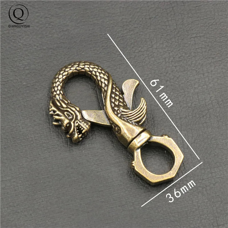 Mousqueton dragon en cuivre sculpté, design robuste de 61 mm par 36 mm, finition patinée artisanale.