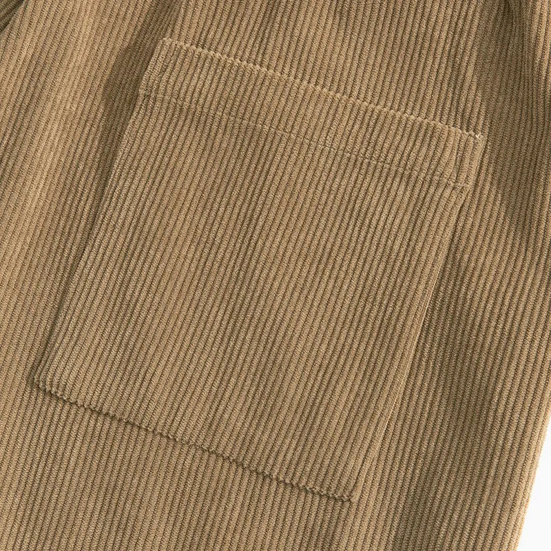 Détail de la texture velours côtelé marron kaki et de la poche plaquée sur un pantalon de détente