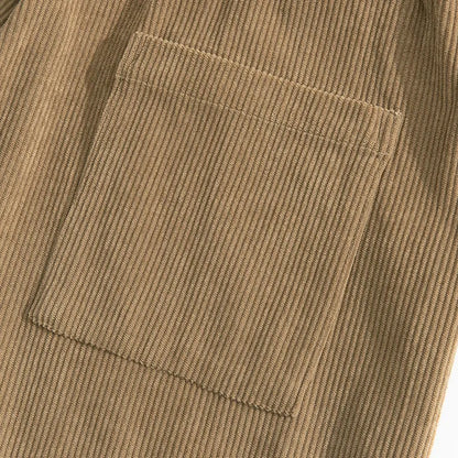 Détail de la texture velours côtelé marron kaki et de la poche plaquée sur un pantalon de détente