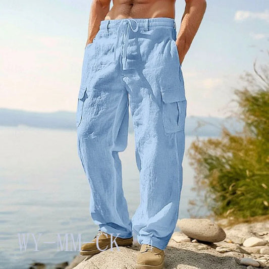 Homme portant le pantalon cargo bleu ciel en lin et coton au bord de l'eau, coupe ample et décontractée