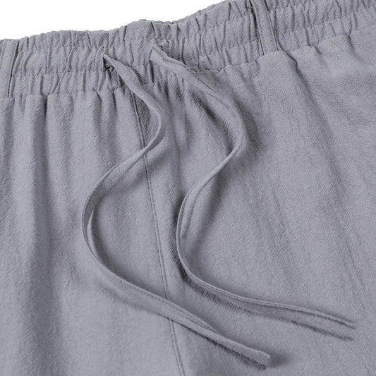 Gros plan sur la taille élastique et le cordon de serrage d'un pantalon gris en textile naturel