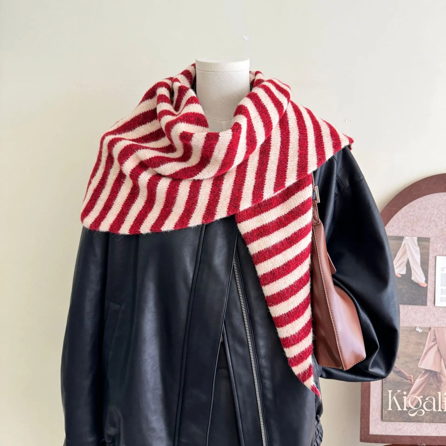 Châle triangle à rayures rouges et crème porté sur un mannequin, style élégant et protecteur.