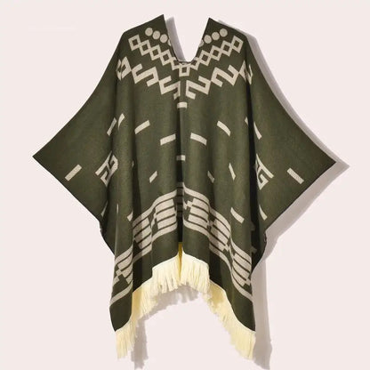 Poncho vert sapin drapé de face avec motifs jacquard crème et franges blanches style bohème.