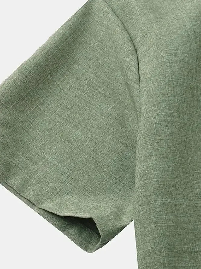 Détail de la manche courte et de la couture soignée sur une chemise légère en lin vert.