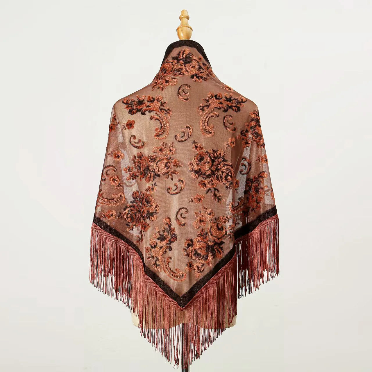 Châle en velours marron orné de motifs floraux et de longues franges, présenté de dos sur un mannequin.