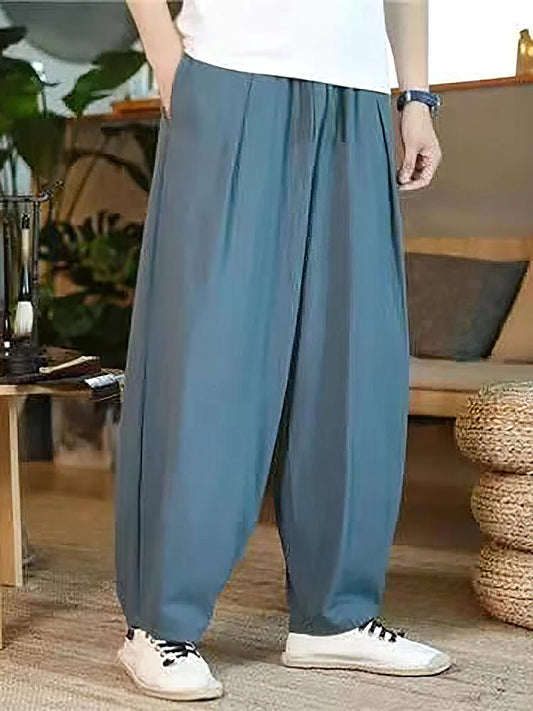 Détail du tombé fluide et de la texture naturelle d'un pantalon large bleu marine en coton et lin.