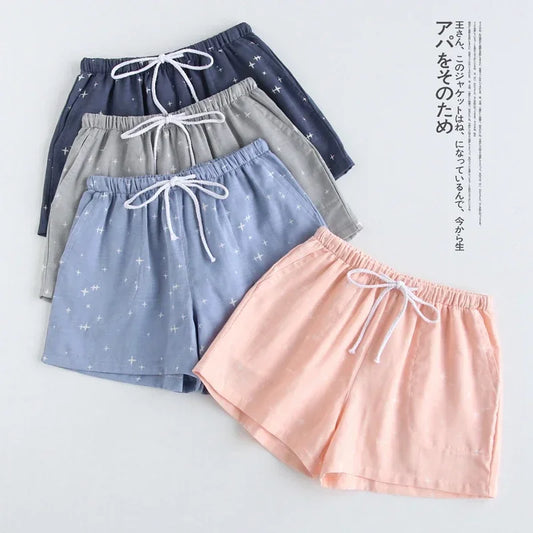 Détail des motifs étoilés et quadrillés sur des shorts de nuit en coton léger bleu ciel, gris perle et rose pastel.