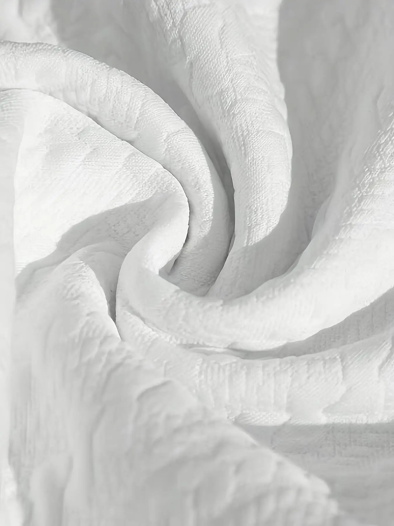 Détail du tissu blanc drapé montrant la souplesse et le relief du tissage jacquard texturé de haute qualité.