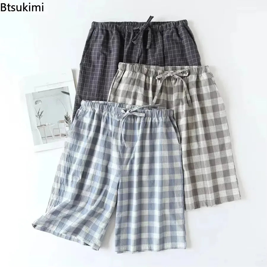 Zoom sur trois shorts de nuit masculins pliés mettant en avant le tissage en coton et les motifs plaid.