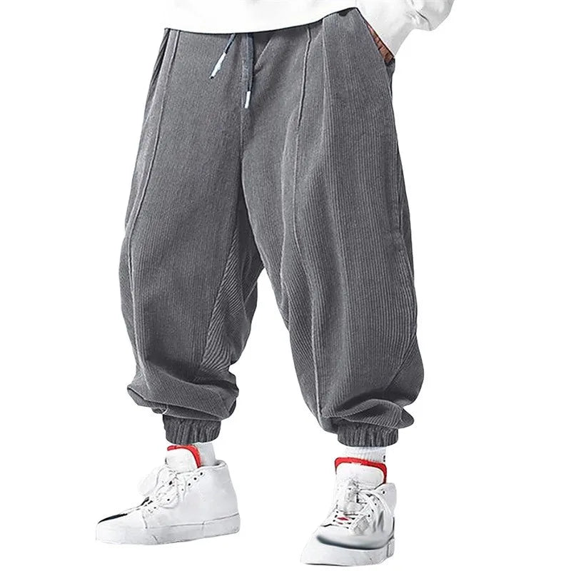 Pantalon ample en velours côtelé gris, matière chaude et confortable pour un look d'hiver décontracté.