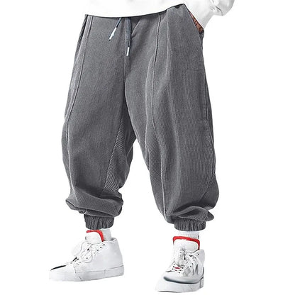 Pantalon ample en velours côtelé gris, matière chaude et confortable pour un look d'hiver décontracté.