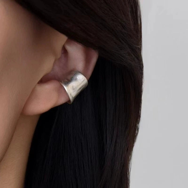Bague d'oreille large en argent vieilli texturé portée sur le cartilage supérieur.