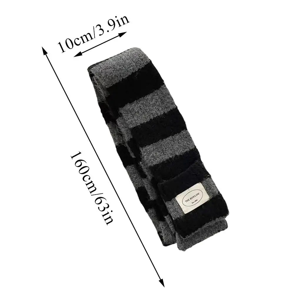 Vue détaillée de la maille épaisse et moelleuse d'une écharpe à rayures horizontales.