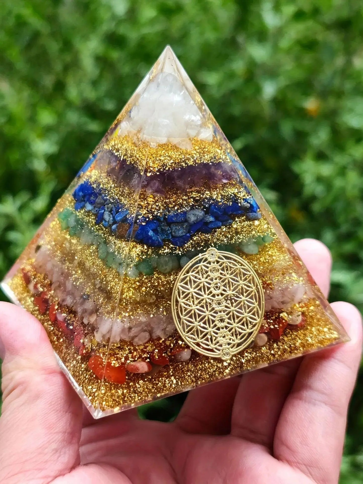 Vue de profil de la pyramide 6cm tenue en main, soulignant la superposition nette des 7 minéraux naturels.