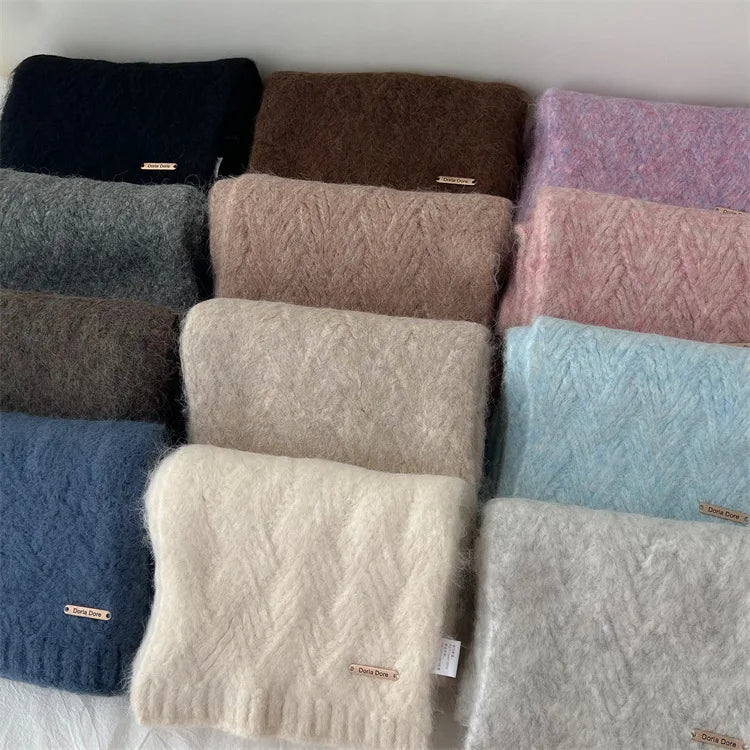 Nuancier de 11 écharpes en laine tricotée, disposées à plat pour montrer la variété des coloris disponibles.