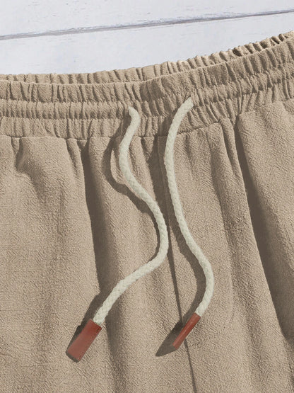 Détail du cordon de serrage blanc avec embouts marron sur le short beige.