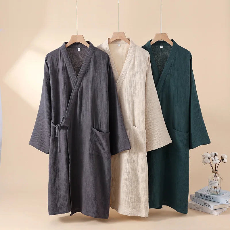 Trois robes kimono japonaises en coton crêpe suspendues, coloris gris anthracite, beige et vert forêt.