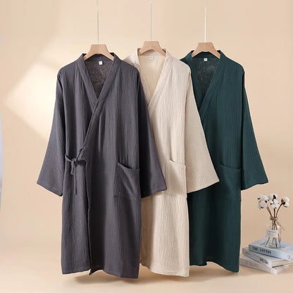 Trois robes kimono japonaises en coton crêpe suspendues, coloris gris anthracite, beige et vert forêt.
