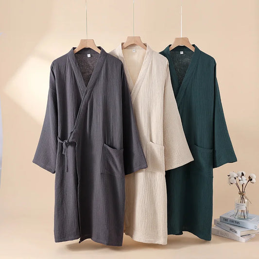 Trois robes kimono japonaises en coton crêpe suspendues, coloris gris anthracite, beige et vert forêt.