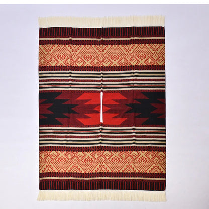 Poncho rouge et noir à plat avec motifs tribaux denses et bordures frangées blanches.